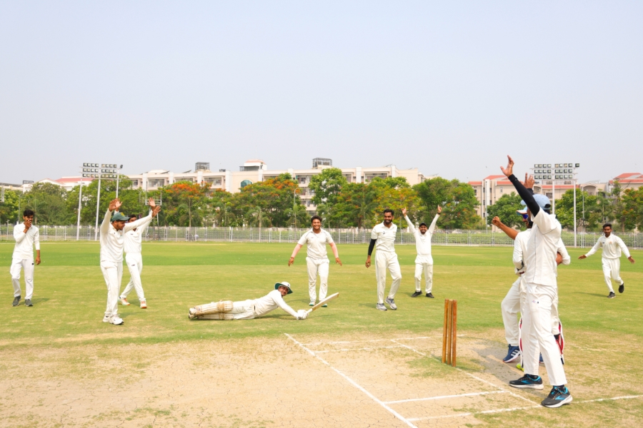 TMU students playing cricket on the university sports ground